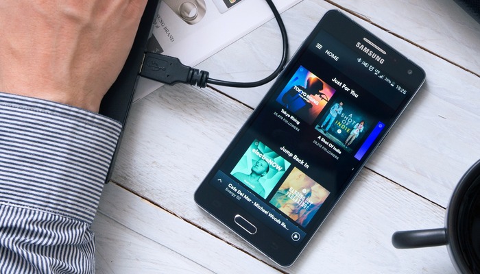 Man uses Spotify application on Samsung A5. Spotify is a Swedish music, podcast, and video streaming service.