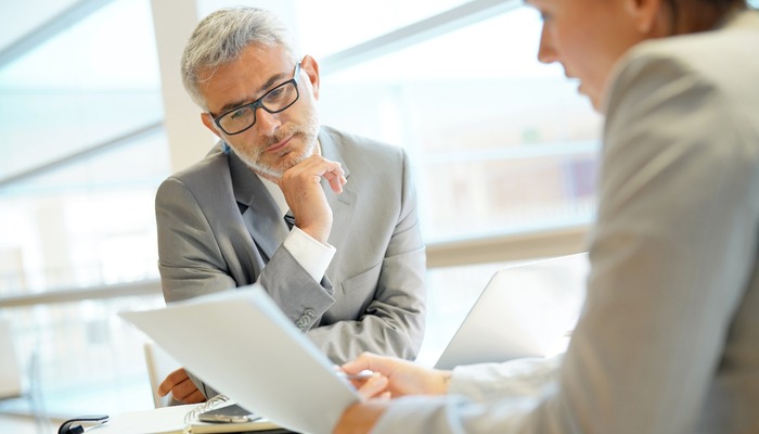 Two colleagues discussing a report in an office