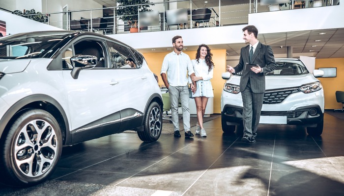 Car salesman showing married couple a car