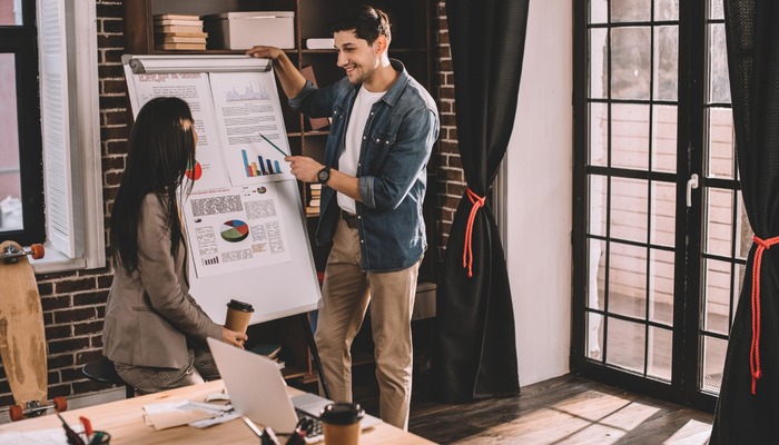 Two colleagues at a startup discussing a marketing plan