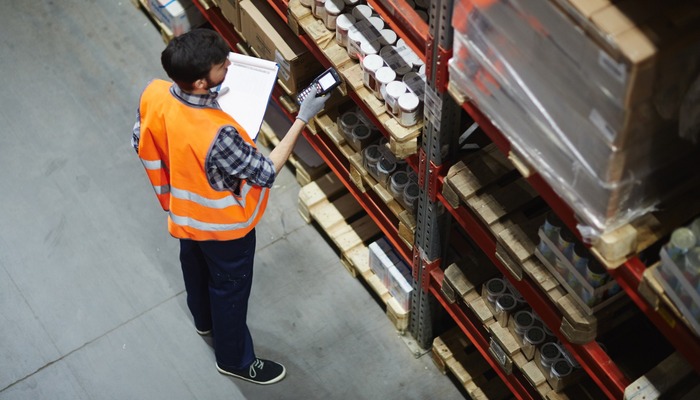 Logistics dispatcher scanning barcodes on packs with goods