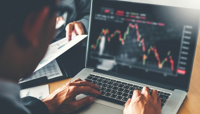 Man reviewing the peaks and troughs of a chart on his laptop